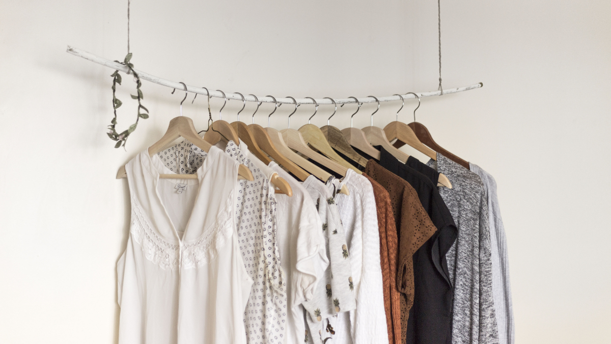 Banana Republic dresses and neutral women’s clothing hanging on wooden hangers in a minimalist wardrobe display.