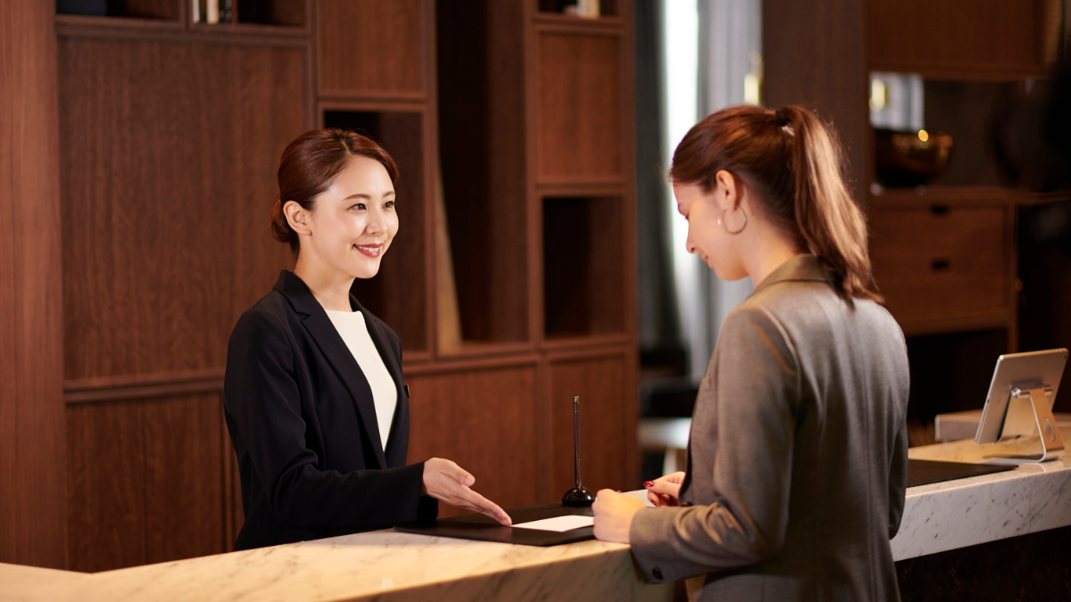 Hotel receptionist assisting a guest with check-in at the front desk